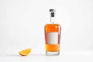 Bottle of liquor with a lemon wedge on a white background photo