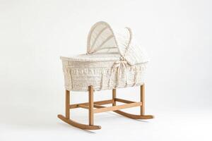 White wicker Moses basket with wooden stand isolated on white background photo