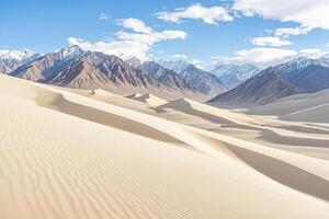 Sand dunes in the desert with snow-capped mountains in the background photo