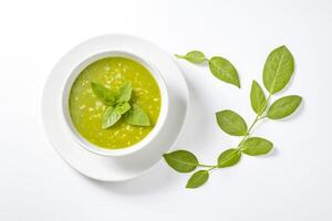 Green soup with basil garnish in a white bowl on a white background photo
