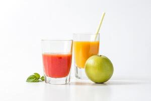 Glass of Tomato Juice with a Green Apple and Orange Juice in the Background photo