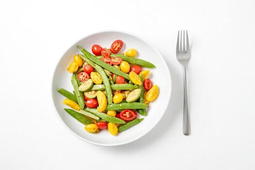 verde frijoles, amarillo Tomates, y rojo Tomates ensalada en un blanco cuenco con un tenedor foto