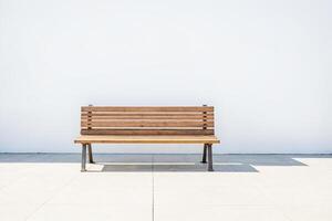 Empty Wooden Bench in Front of White Wall photo