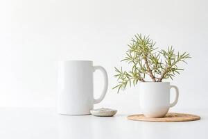 White ceramic pitcher and mug with a potted plant on a white surface photo