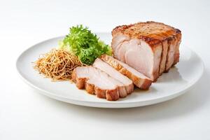 Roasted Pork with Crispy Skin, Noodles and Greens on a White Plate photo
