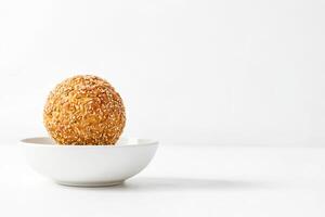 Close Up Of A Single Round Bread Roll In A White Bowl Against A White Background photo
