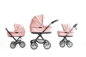 Three pink baby strollers in a row photo