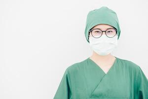 Portrait of young Asian nurse with surgeon uniform, wearing a surgical mask for protection from inhaling airborne bacteria or virus disease. photo