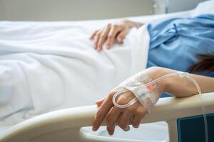 Patient woman sleeping with receiving intravenous fluid directly into a vein. photo