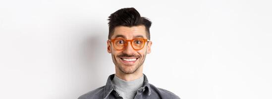 Close up portrait of happy man face, wearing stylish glasses and smiling, standing on white background photo