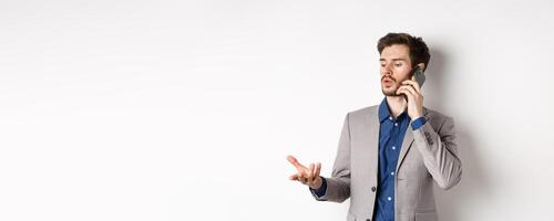 Handsome businessman having business call on phone, gesturing while talking on mobile, having conversation, white background photo