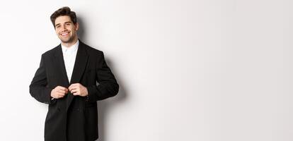 Image of handsome and confident businessman with beard, button down jacket and smiling, standing against white background photo