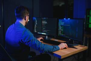 Male programmer working on desktop computer at white desk in office photo