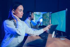 Friendly smiling woman call center operator with headset using computer at office photo