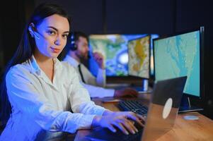 Friendly smiling woman call center operator with headset using computer at office photo