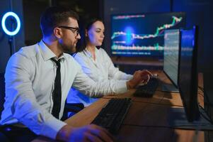 Team of traders working at monitor computer and browsing online in trading office photo