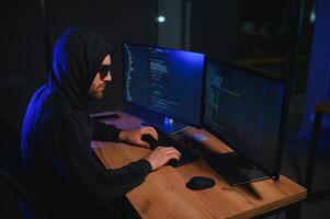 Wanted hackers coding virus ransomware using laptops and computers. Cyber attack, system breaking and malware concept photo