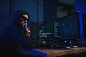 Programmer or computer hacker typing code photo