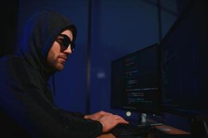 Hacker is hacking into the computer network. Computer criminal photo