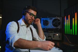 Secret agent listens on the reel tape recorder. Officer wiretapping in headphones. Spying of conversations. Intelligence gathering. Espionage concept photo