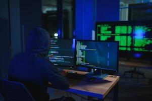 Programmer or computer hacker typing code photo