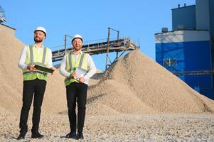 Two engineers at a stone crushing plant. The concept of quarrying. photo