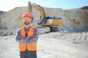 Portrait of a worker standing on the background of a stone quarry photo