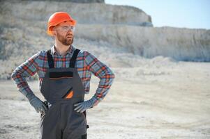 Portrait of a worker standing on the background of a stone quarry photo