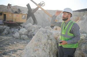 Portrait of a worker standing on the background of a stone quarry photo