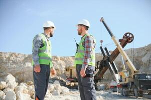 Two workers and quarry in background photo