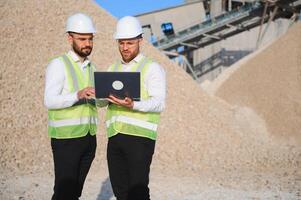 Two engineers at a stone crushing plant. The concept of quarrying. photo