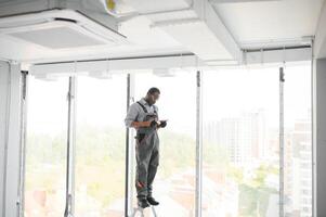 hvac worker install ducted pipe system for ventilation and air conditioning. copy space photo