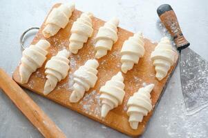 Close up on raw croissants before baking. Classic French pastry made of Viennoiserie dough with vanilla creme photo