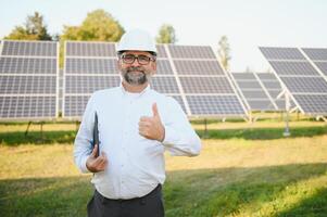 ingeniero hombre en casco en el campo de solar paneles foto