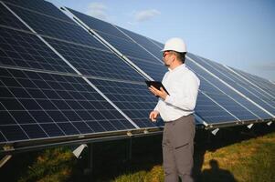 ingeniero hombre en casco en el campo de solar paneles foto