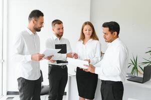 Happy businesspeople laughing while collaborating on a new project in an office. Group of diverse businesspeople working together in a modern workspace photo