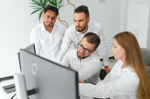 Happy businesspeople laughing while collaborating on a new project in an office. Group of diverse businesspeople working together in a modern workspace photo