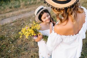 Mother and daughter having fun in the park. Happiness and harmony in family life. Beauty nature scene with family outdoor lifestyle. Mother's Day photo