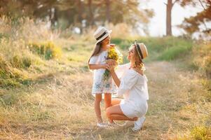 Mother and daughter having fun in the park. Happiness and harmony in family life. Beauty nature scene with family outdoor lifestyle. Mother's Day photo