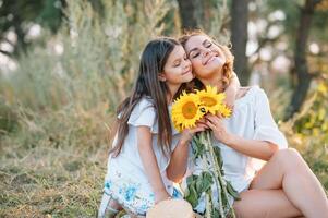 Mother and daughter having fun in the park. Happiness and harmony in family life. Beauty nature scene with family outdoor lifestyle. Mother's Day photo
