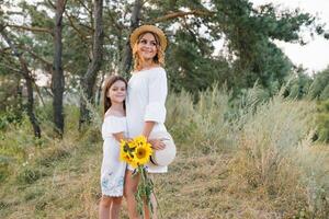 Mother and daughter having fun in the park. Happiness and harmony in family life. Beauty nature scene with family outdoor lifestyle. Mother's Day photo