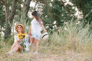 Mother and daughter having fun in the park. Happiness and harmony in family life. Beauty nature scene with family outdoor lifestyle. Mother's Day photo
