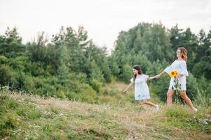 Mother and daughter having fun in the park. Happiness and harmony in family life. Beauty nature scene with family outdoor lifestyle. Mother's Day photo