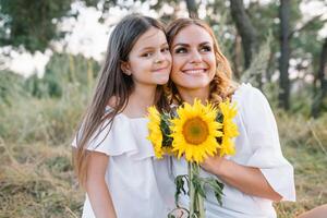 Mother and daughter having fun in the park. Happiness and harmony in family life. Beauty nature scene with family outdoor lifestyle. Mother's Day photo