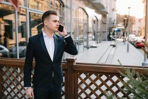 Young business man with a smartphone near of modern building. photo