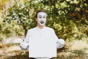 Your text here. Actors mimes holding empty white letter. Colorful portrait with green background. April fools day photo