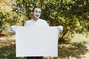 Your text here. Actors mimes holding empty white letter. Colorful portrait with green background. April fools day photo