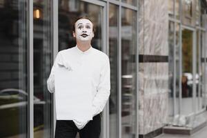Your text here. Actor mime holding empty white letter. Colorful portrait with gray background. April fools day photo