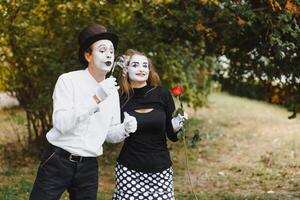 Mime artist blowing a bubble through wand on green background photo