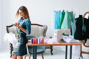 Can't make any mistake. Female fashion designer works on the new clothes in the workshop. photo